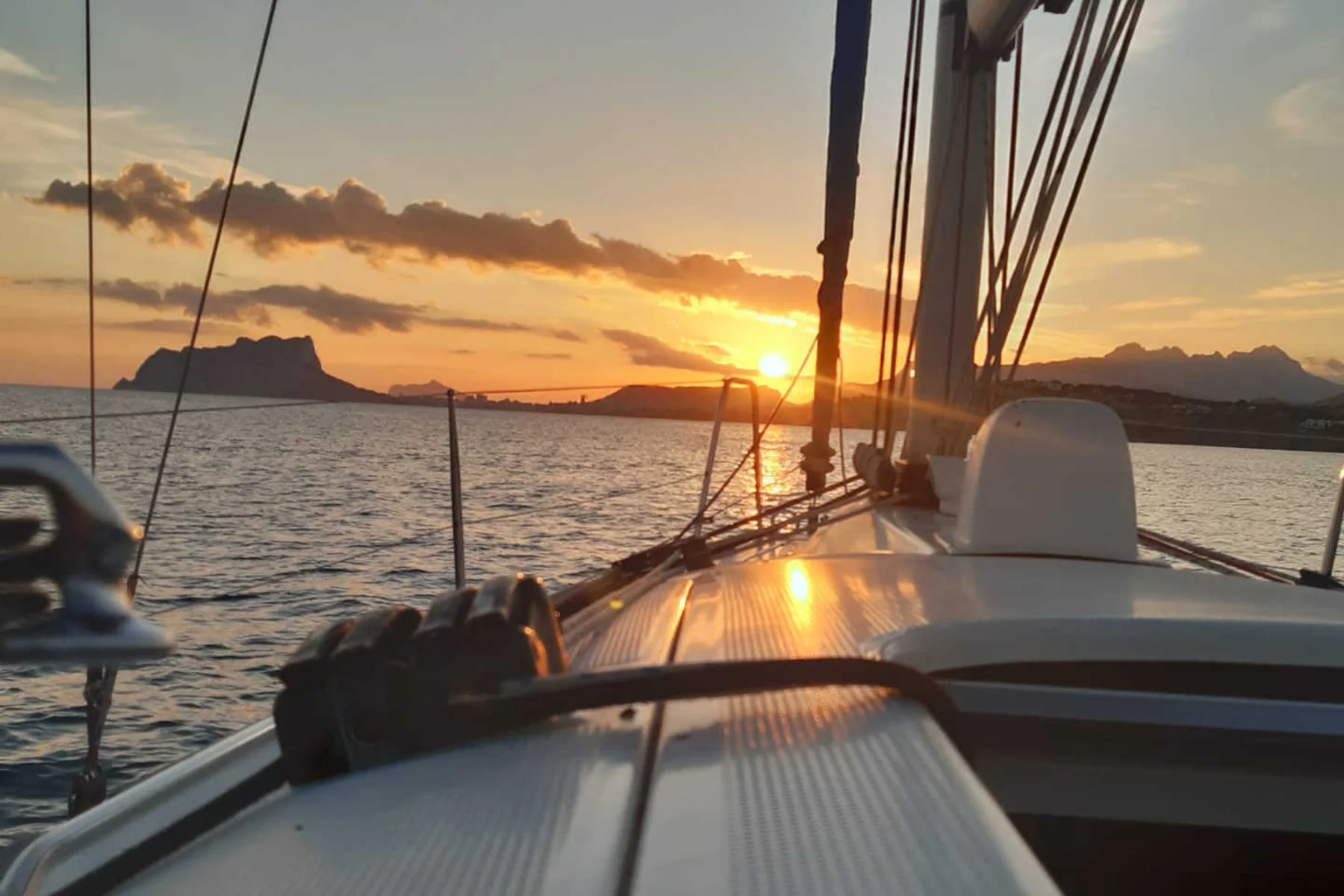 The sun rising beside the mast and sail